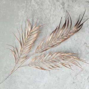 Gold artificial palm leaf branch detail view for wedding and home decoration floral arrangement.