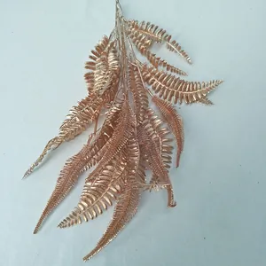 Detailed closeup of a golden artificial fern frond, perfect for wedding and event decor.