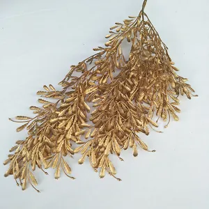 Gold artificial fern leaf branch detail, perfect for wedding decoration and floral display.