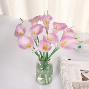Détail de fleurs de lys calla artificielles en PU rose arrangement dans vase.