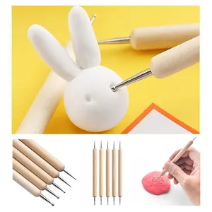 Detailed view of pottery clay sculpting tools with wooden handles and dual metal ball heads for art.