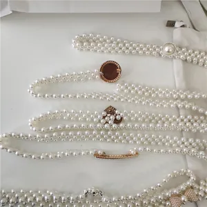 Pearl waist chain detail showcasing multi-strand beaded design and various metal buckles.