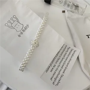 Exquisite pearl belt detail shot, delicate beaded design for elegant women dresses.