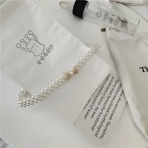Detail view of women's Korean fashion pearl waist belt, elegant beaded elastic dress accessory.