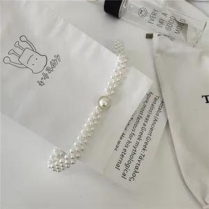 Detailed shot of multi-layer pearl waist chain dress belt with elegant centerpiece for women.