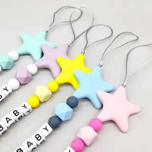 Detail view of colorful silicone pacifier clips with star beads and BABY letter charms