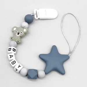 Close-up detail of a gray silicone baby pacifier clip with koala and star charms