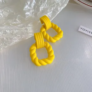Acrylic twist earrings detail shot, vibrant yellow fashion jewelry for women daily wear.