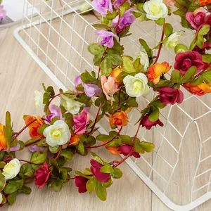 Artificial rose vine garland detail shot, colorful faux silk floral decor for home garden.