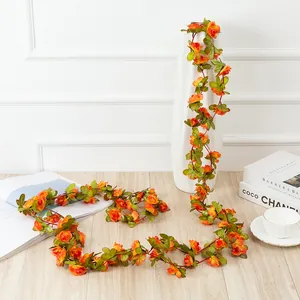 Artificial orange rose flower garland vine with green leaves for home party decor.