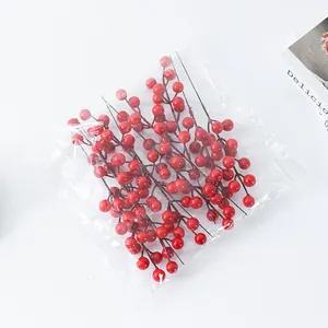 Artificial red berry branches for home decor, fake holly fruits for New Year flower arrangement.