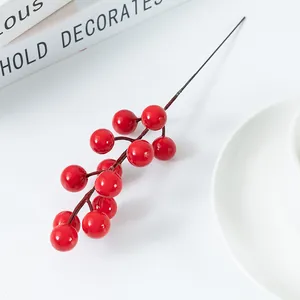 Close-up detail of artificial red berry branch for Christmas home decoration and floral arrangement.