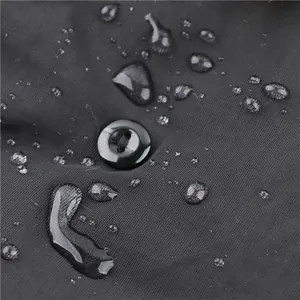 Detailopname van waterdichte stof met waterdruppels op donker wintermutsmateriaal.