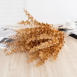 Golden artificial eucalyptus leaf branches for home decor, vase filler, floral arrangements.