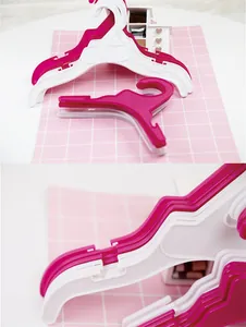 Plastic clothes hanger detail view, small size for pet or children apparel, hook design.
