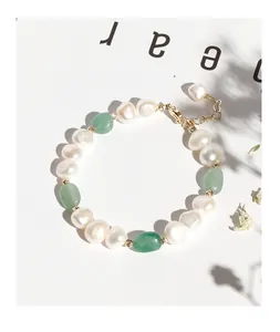 Detail view of irregular freshwater pearls and green aventurine stone beads on a bracelet