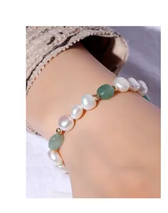 Detailed macro view of irregular freshwater pearl bracelet with green aventurine accents