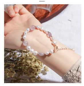 Detailed view of an elegant irregular freshwater pearl and purple crystal bracelet worn on wrist