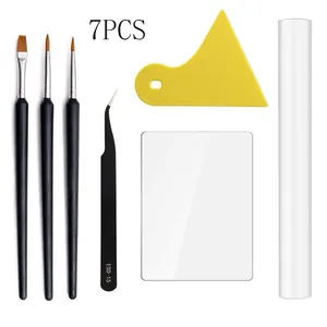Detailed view of pottery tool set components including brushes, tweezers, scrapers and roller.