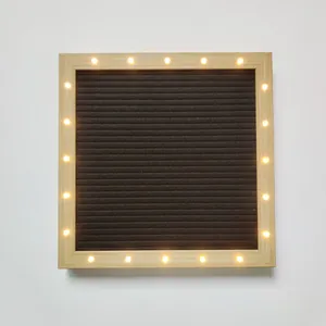 Gros plan detaille du tableau a lettres en feutre carre avec cadre en bois et LED chaudes.