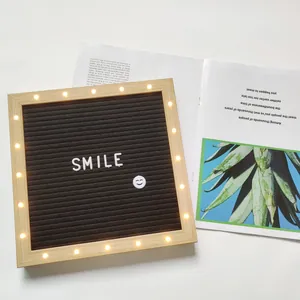 Gros plan sur le tableau à lettres LED en bois avec fond en feutre et lumières chaleureuses.