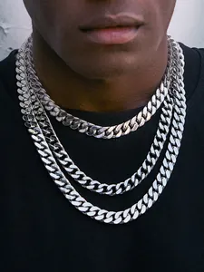 Close-up of three layers of chunky stainless steel Cuban link necklaces on a model