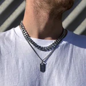 Close-up of stainless steel Cuban chain and razor blade pendant on white t-shirt