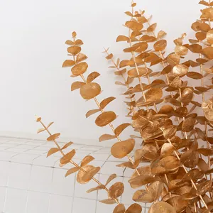 Close-up detail of artificial golden eucalyptus branches showing metallic finish for decor.