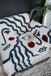 Nordic abstract face knit sofa blanket throw cover, stylish home decor textile detail.