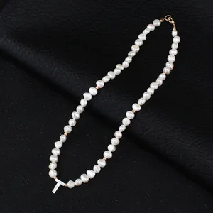 Freshwater pearl necklace detail showing the shell letter T pendant and metal beads.