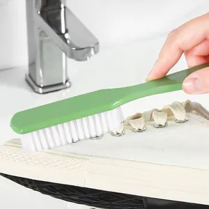 Ergonomic green plastic shoe cleaning brush with stiff white bristles for versatile home use