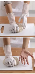 Gedetailleerd zicht op witte latex schoonmaakhandschoenen die deeg kneden op plank.