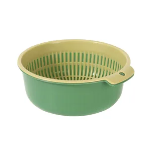 Large green and beige double-layer drain basket for washing vegetables in the kitchen.