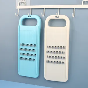 Two multipurpose handheld vegetable grater slicers in blue and white colors hanging on a rack