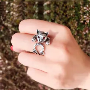 Nahaufnahme Detail eines süßen Katzen Wickelrings mit roten funkelnden Augen und offener Schiene.