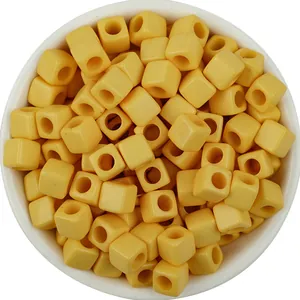 Yellow acrylic square beads closeup, solid cube large hole spacer for DIY handmade jewelry crafts.
