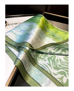 Green silk scarf detail, artistic landscape print mulberry silk ribbon close-up texture.