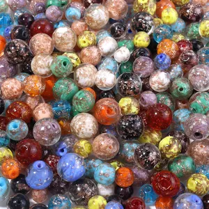 Detail shot of colorful glass beads with gold foil specks for DIY jewelry making.