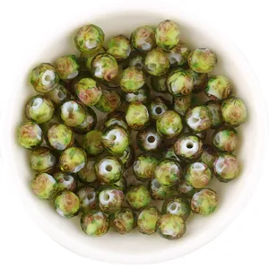 Detailed view of green millefiori glass beads, gold sand faceted abacus loose beads for DIY crafts.