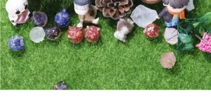 Macro view of colorful resin owl figurines with crystal gravel on artificial grass