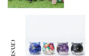 Close-up view of four colorful owl resin figurines inlaid with natural crystal gravel