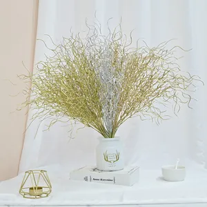 Decorative gold and silver artificial curly willow branches in a white vase setup