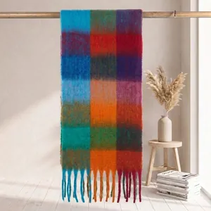 Vista dettagliata di una spessa sciarpa a quadri tipo mohair con frange appesa a un'asta