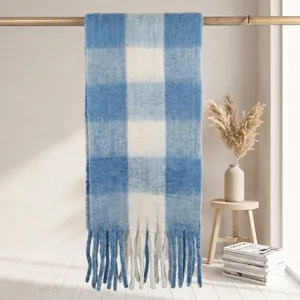 Dettaglio di una sciarpa a quadri blu e bianchi in finto mohair con lunghe frange