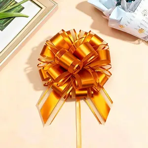Detail einer goldenen Schleife aus Metallic-Band für festliche Weihnachtsgeschenke.