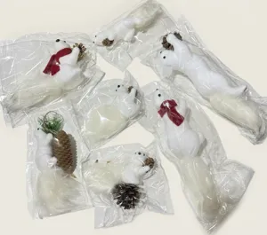Multiple white foam squirrel Christmas ornaments with pinecones in clear packaging