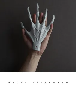 Detailed view of a realistic Halloween skeleton hand claw being held for scale