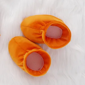 Orange infant shoes detail view, soft velvet baby booties showcasing cozy texture and color.