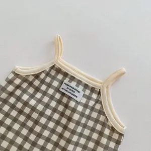 Dettaglio tutina neonato a quadri, body estivo senza maniche per neonati stile alla moda.
