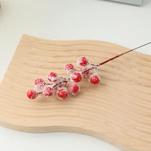 Close-up detail of artificial frosted red berry branch for Christmas DIY floral decor.